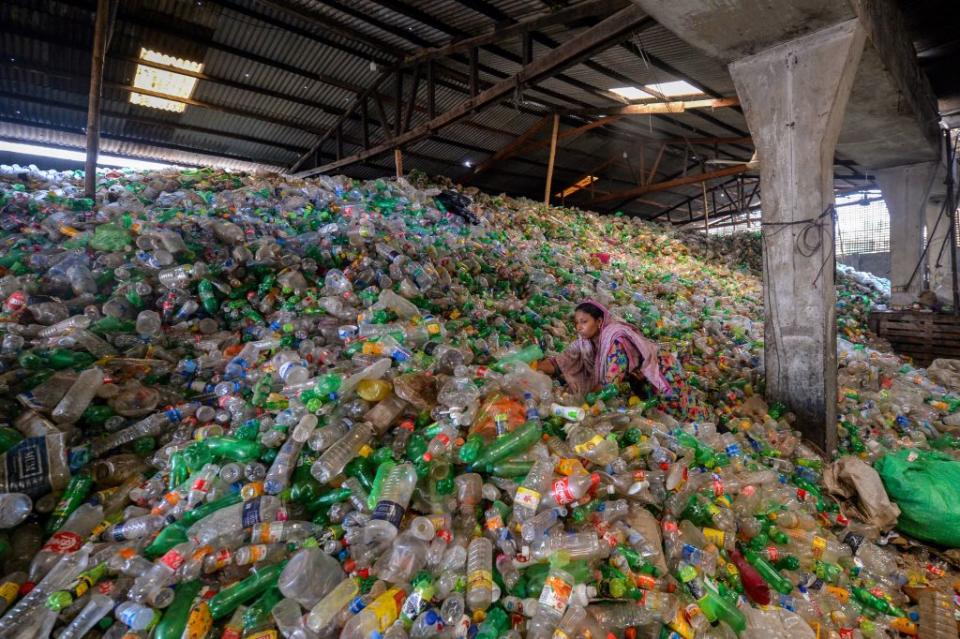 A worker sorts used plastic bottles in a recycling factory in Dhaka.