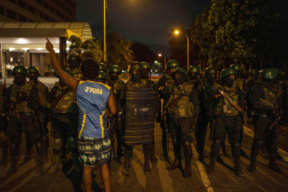 A protester shouts slogans as Army soldiers arrive from the site of a protest camp outside the Presidential Secretariat in Colombo, Sri Lanka, Friday, July 22, 2022. (AP Photo/Rafiq Maqbool)