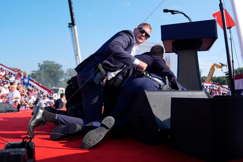 Secret Service members are seen atop former president Donald Trump following an incident at his rally.