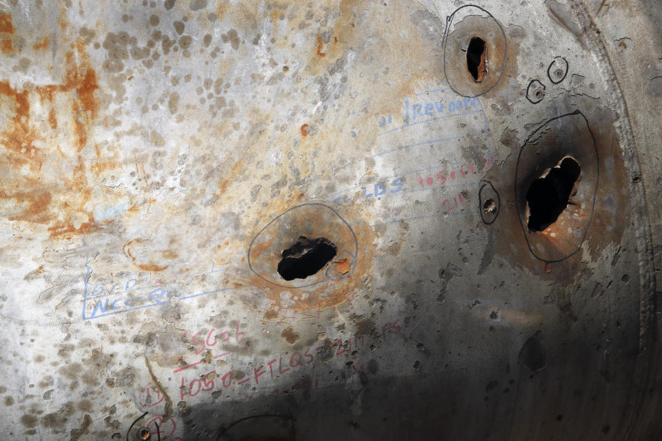 In this photo opportunity during a trip organized by Saudi information ministry, holes caused by fragments of a missile are seen in a damaged pipe in the Aramco's Khurais oil field, Saudi Arabia, Friday, Sept. 20, 2019, after it was hit during Sept. 14 attack. Saudi officials brought journalists Friday to see the damage done in an attack the U.S. alleges Iran carried out. Iran denies that. Yemen's Houthi rebels claimed the assault. (AP Photo/Amr Nabil)