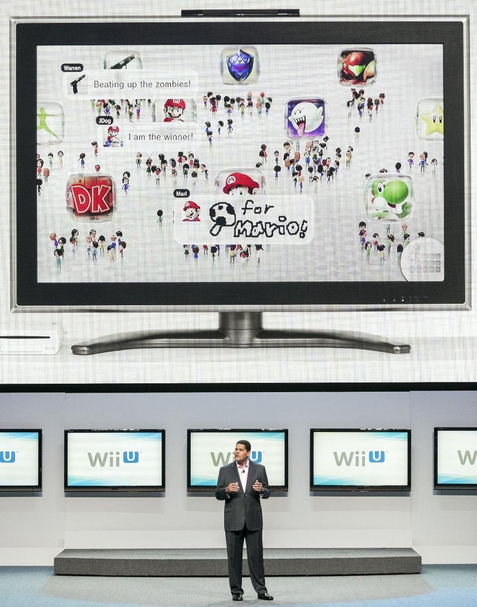 FILE - In this June 5, 2012 file photo, Reggie Fils-Aime, president and CEO of Nintendo America, Inc., presents the Wii U as the next-generation game console at the Nintendo All-Access presentation at E3 2012 in Los Angeles. It can scan zombies, replace a TV remote, open a window into virtual worlds and shoot ninja stars across a living room. It's the Wii U GamePad, the 10-by-5-inch touchscreen controller for the successor to the Wii out Sunday, Nov. 18, 2012, and if you ask the brains behind the "Super Mario Bros." about it, they say it's going to change the way video games are made and played. (AP Photo/Damian Dovarganes, File)