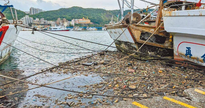 基隆市八斗子漁港4日上午突然出現大量油汙與被颱風打進港內的海漂垃圾，汙染港內水質，中油緊急派員在現場清理。（圖／張志康攝）