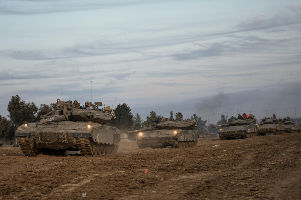Israeli soldiers move tanks at a staging area near the border with the Gaza Strip, southern Israel, Tuesday, Nov. 28, 2023. on the fifth day of a temporary cease-fire between Israel and Hamas. (AP Photo/Ohad Zwigenberg)