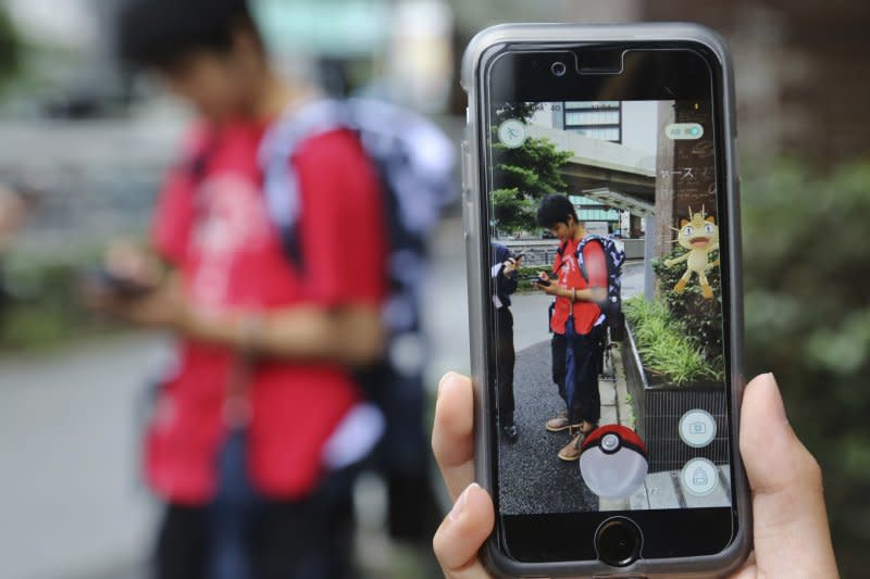 <cite>日本的年輕人在東京街頭玩Pokémon GO（美聯社）</cite>