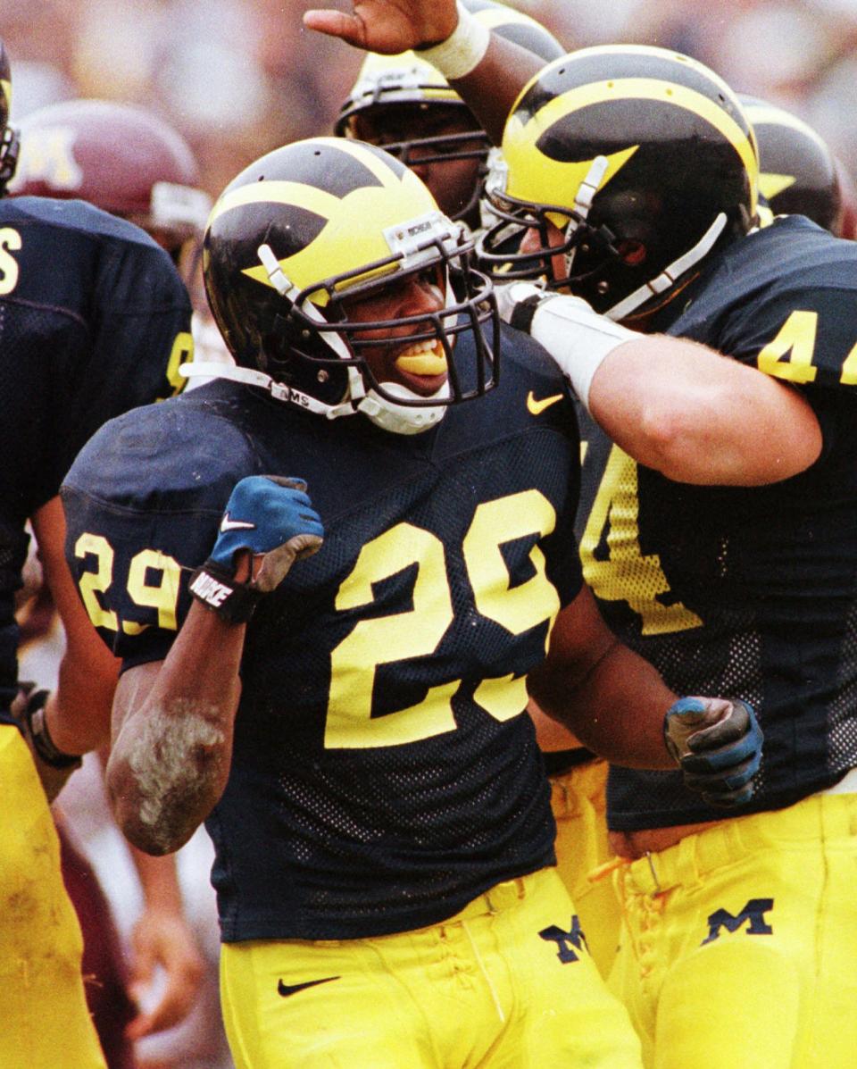 In this file photo taken Nov. 1, 1997, Michigan safety Marcus Ray (29) celebrates with his teammates at Michigan Stadium in Ann Arbor, Mich.