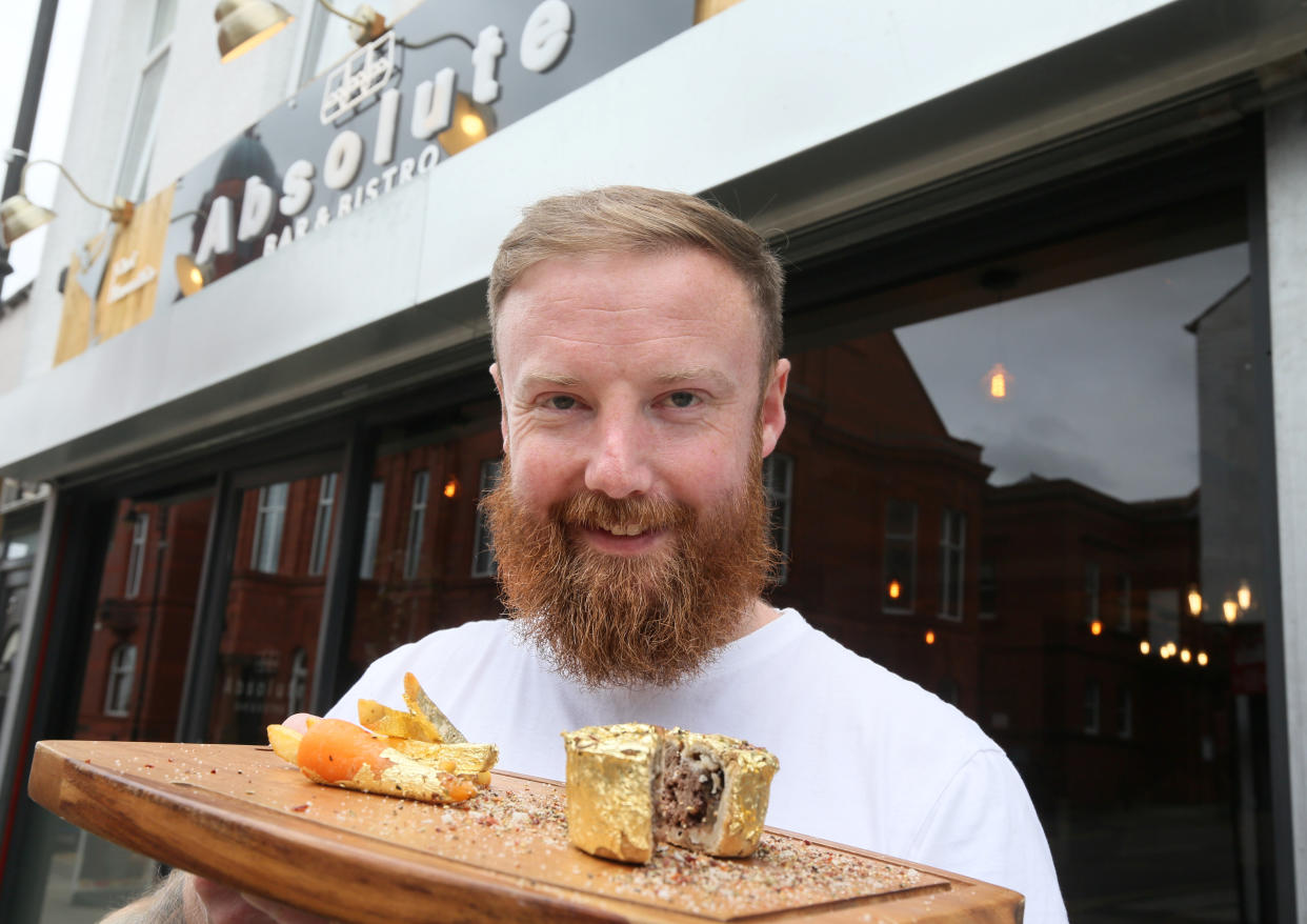 Chef Gareth Mason from the Absolute Bar and Bistro, Bolton, who took the challenge to see if everyday food could be improved by presenting it in the style of famous chef, Salt Bae.  See SWNS story SWLEbae.  A northern chef created his own take on Salt Bae's menu with Lancashire-inspired dishes - only to be told by a jeweller they were worth just 5p.  Gareth Mason, 33, covered his signature Whist Pies, mini meat pies popular in Lancashire, in edible 24-carat gold leaf to mock Nusret Gokce's 'ludicrous' menu.  Also on the makeshift menu were gold-wrapped chips, bacon and gold sausage butties  and a 24-carat carrot.  But while the Turkish butcher-turned-steakmonger charges £850 for his steaks, Gareth's dishes were valued at just 5p by a local jewellery store.   Gareth said: 