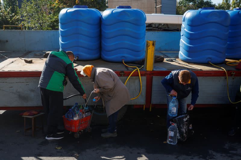 Local people fill up bottles with fresh drinking water in Mykolaiv