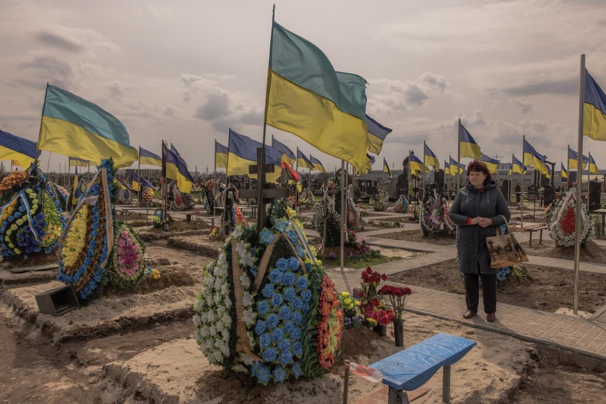A woman visits the part of a cemetery in Brovary, Ukraine, where Ukrainian soldiers are buried in April. Tens of thousands of Ukrainians have been killed in the conflict. (Roman Pilipey/Getty Images - image credit)