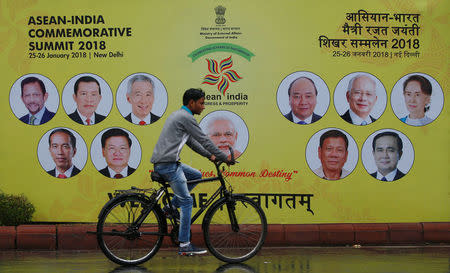 A cyclist rides past an ASEAN-India Commemorative Summit billboard the side of the road in New Delhi, India, January 23, 2018. REUTERS/Adnan Abidi