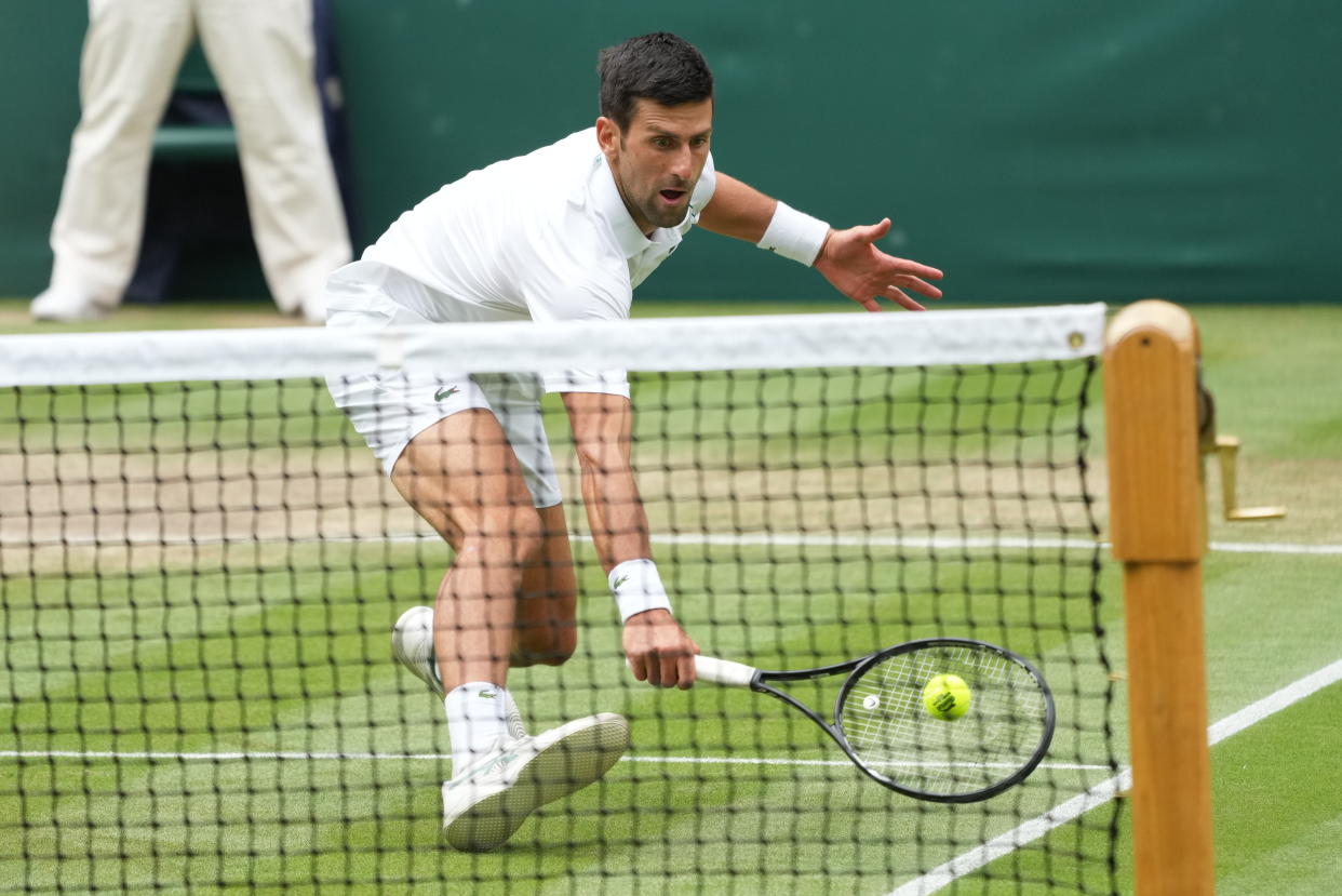 Serbia's Novak Djokovic plays during the men's singles quarterfinals match against Hungary's Marton Fucsovics on day nine of the Wimbledon Tennis Championships in London, Wednesday, July 7, 2021. (AP Photo/Alberto Pezzali)