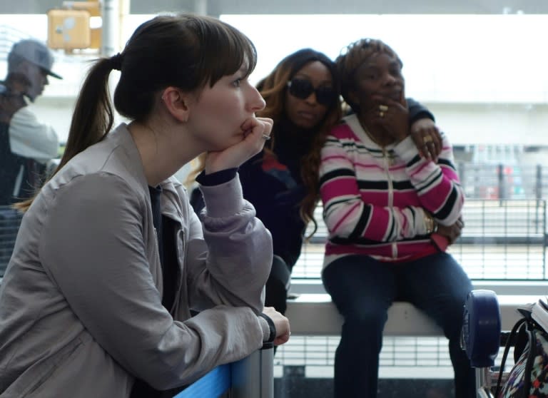 British Airway's passengers wait in line to re-check into an American Airlines flight at John F. Kennedy (JFK) international airport in New York, on May 27, 2017