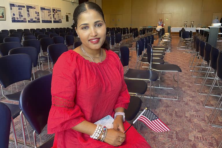 Heaven Mehreta, de 32 años, sonríe y sostiene una pequeña bandera estadounidense dentro del Templo Mount Zion en St. Paul, Minnesota, el 21 de junio de 2023, después de convertirse en ciudadana estadounidense en una ceremonia de naturalización. 