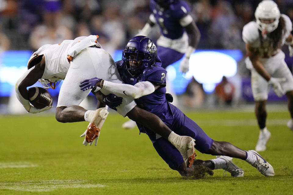 TCU cornerback Josh Newton (2) makes a tackle on Texas running back CJ Baxter during the second half of an NCAA college football game, Saturday, Nov. 11, 2023, in Fort Worth, Texas. Texas won 29-26. (AP Photo/Julio Cortez)