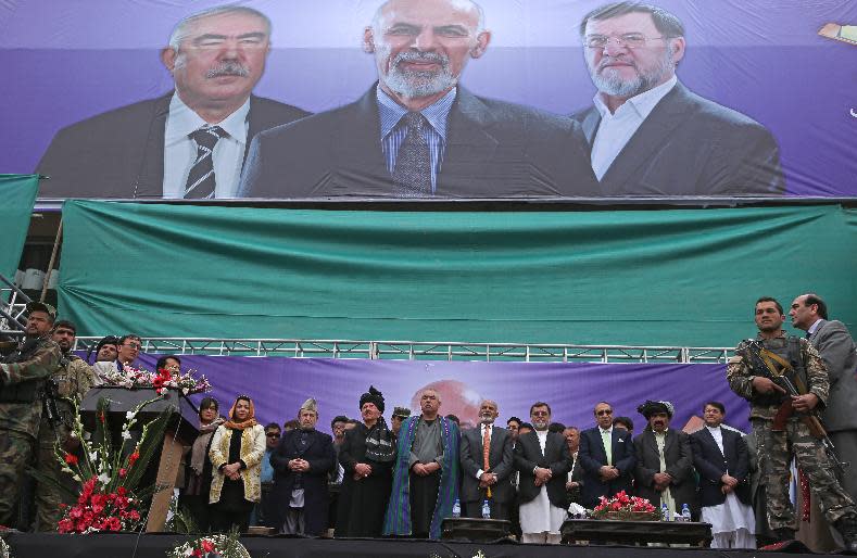 Afghan presidential candidate Ashraf Ghani Ahmadzai, fifth from right, and his two vice presidential candidates listen to the national anthem during a campaign rally in Kabul, Afghanistan, Tuesday, April 1, 2014. Eight Afghan presidential candidates are campaigning for the third presidential election. Elections will take place on April 5, 2014. (AP Photo/Massoud Hossaini)