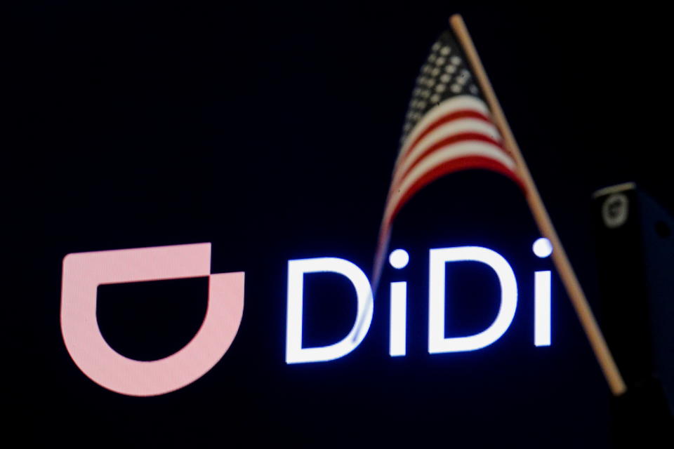 An American flag is seen in front of the logo for Chinese ride hailing company Didi Global Inc. during the IPO on the New York Stock Exchange (NYSE) floor in New York City, U.S., June 30, 2021.  REUTERS/Brendan McDermid