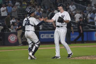 New York Yankees catcher Jose Trevino, left, slap hands with relief pitcher Clay Holmes (35) after the team's win over the Tampa Bay Rays in a baseball game Tuesday June 14, 2022, in New York. (AP Photo/Bebeto Matthews)
