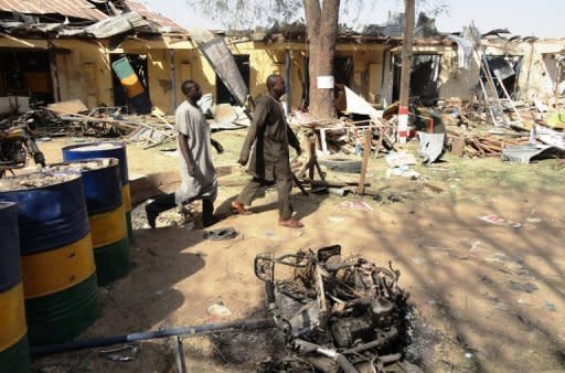 Two residents pass by bombed corner shops attached to police barracks in the northern Nigerian city of Kano after multiple explosions and gun assaults by Boko Haram Islamists in January 2012. Nigeria, Africa's most populous nation and largest oil producer, is divided between a Muslim north and predominantly Christian south. Boko Haram has said it wants to create an Islamic state in the north