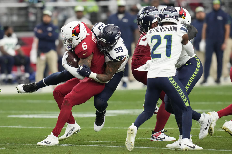 Arizona Cardinals running back James Conner (6) is brought down by Seattle Seahawks defensive end Leonard Williams (99) after Conner gained a first down in the first half of an NFL football game Sunday, Jan. 7, 2024, in Glendale, Ariz. (AP Photo/Ross D. Franklin)