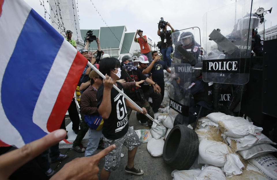 Anti-government protesters attempt to hold back riot police trying to retake a protest site in Bangkok, Thailand, Friday, Feb. 14, 2014. Riot police cleared anti-government protesters from a major boulevard in the Thai capital in a small victory for authorities Friday as they try to reclaim areas that have been closed during a three-month push to unseat Prime Minister Yingluck Shinawatra. (AP Photo/Wally Santana)