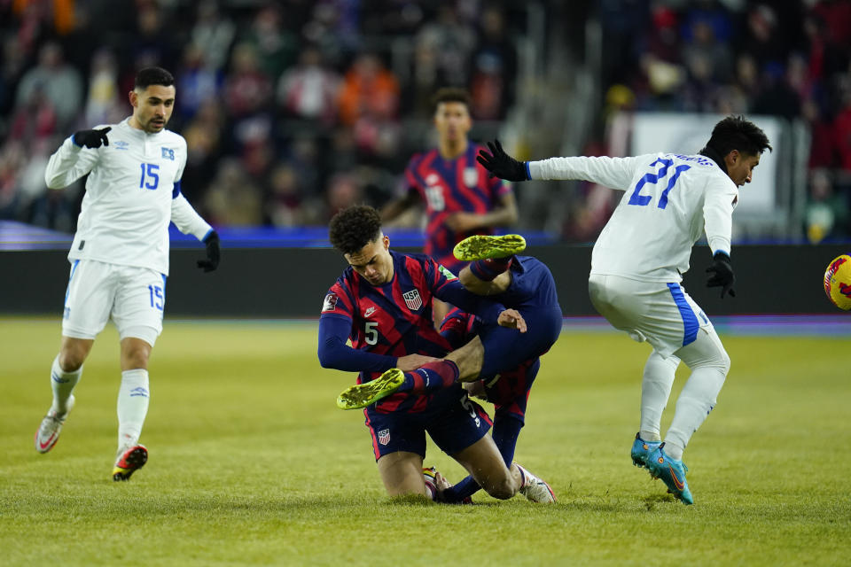 United States' Christian Pulisic, center right, collides with teammate Antonee Robinson, center left, as they compete for possession with El Salvador's Bryan Tamacas (21) and Alex Roldan (15) during the first half of a FIFA World Cup qualifying soccer match, Thursday, Jan. 27, 2022, in Columbus, Ohio. (AP Photo/Julio Cortez)