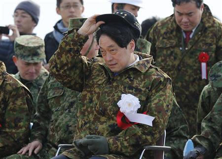 Japan's Defence Minister Itsunori Onodera (C) adjusts his cap as he inspects the annual new year military exercise by the Japanese Ground Self-Defense Force 1st Airborne Brigade during at Narashino exercise field in Funabashi, east of Tokyo January 12, 2014. REUTERS/Issei Kato