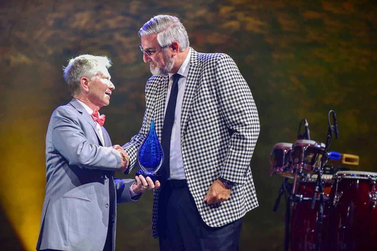 Indiana Gov. Eric Holcomb receives the Rialzo Spirit of Meridian Award during the Rialzo XI gala on May 14, 2022, at Ball State University's Scheumann Family Indoor Practice Facility.