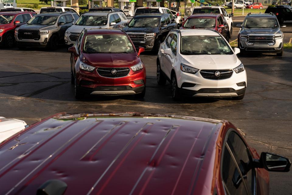 Vehicles sit damaged at Todd Wenzel Buick GMC of Davison, Michigan, after baseball-sized hail came through during a storm that moved through on July 20.