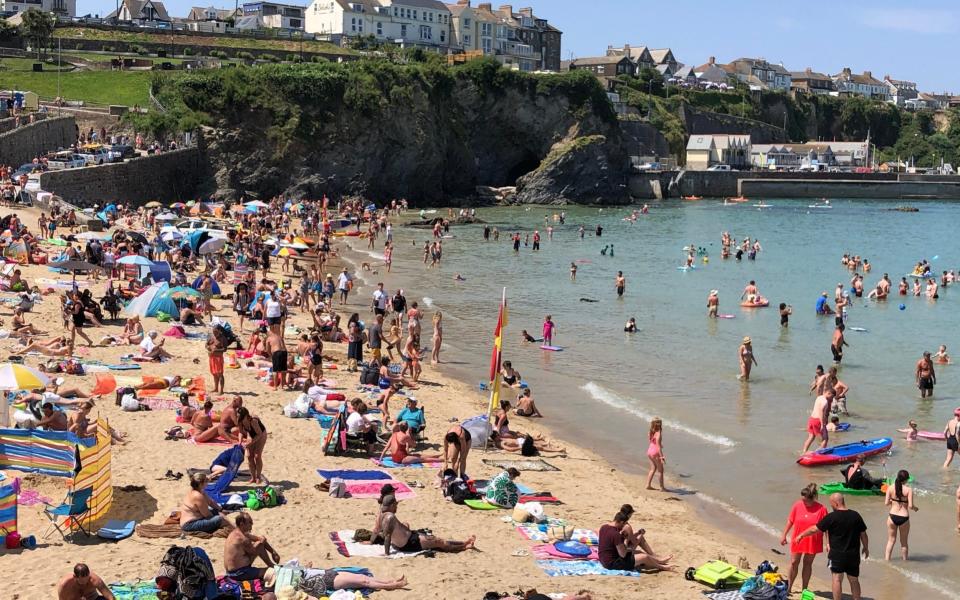 Holidaygoers in Cornwall enjoy the sunny weather on Newquay's Towen beach on 20 July 2021 - Jam Press/Jam Press