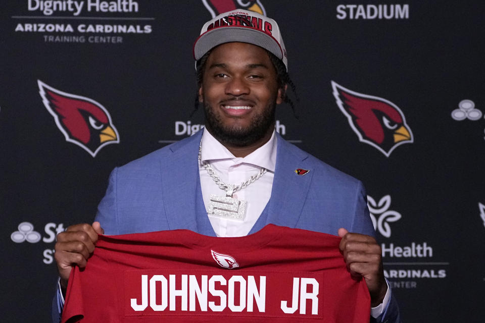 Arizona Cardinals first-round draft pick Paris Johnson Jr. hold up his jersey after being introduced, Friday, April 28, 2023, at the NFL football team's training facility in Tempe, Ariz. (AP Photo/Matt York)