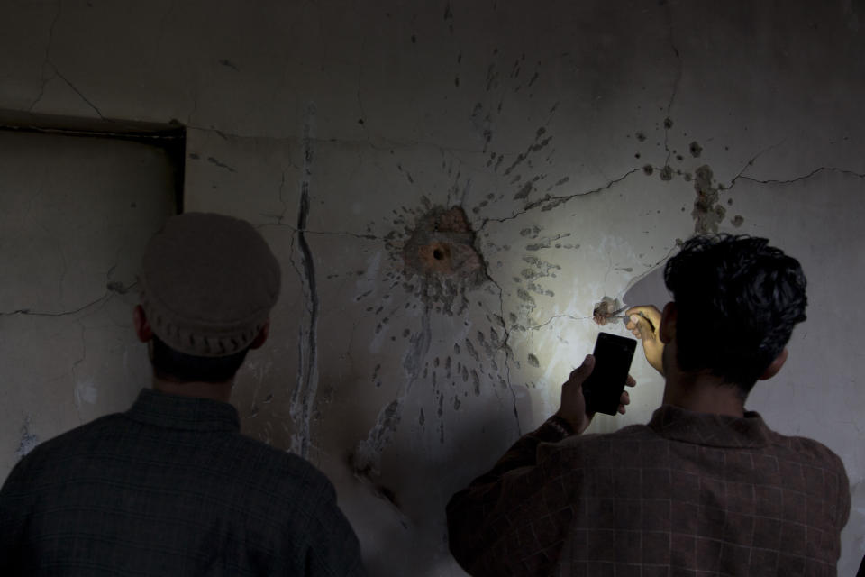 A Kashmiri boy tries to take out a bullet out from the wall of a damaged house after a gunbattle in Tral, south of Srinagar, Indian controlled Kashmir, Friday, May 24, 2019. Government forces in Indian-controlled Kashmir killed a top militant commander linked to al-Qaida in the disputed region, officials said on Friday. (AP Photo/ Dar Yasin)