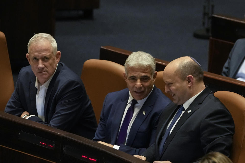 Israeli Defence Minister Benny Gantz, left, Foreign Minister Yair Lapid, center, and Prime Minister Naftali Bennett attend a preliminary vote on a bill to dissolve parliament, at the Knesset, Israel's parliament, in Jerusalem, Wednesday, June 22, 2022. Lawmakers voted in favor of dissolving parliament in a preliminary vote, setting the wheels in motion to send the country to its fifth national election in just over three years. Once it passes, Bennett will step down as prime minister and hand over the reins to his ally, Lapid. New elections are expected to be held in October. (AP Photo/Maya Alleruzzo)