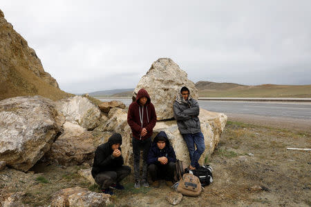 A group of Afghan migrants rest, during a break from their walk, on a main road, after crossing the Turkey-Iran border near Dogubayazit in Agri province, eastern Turkey, April 11, 2018. Picture taken April 11, 2018. REUTERS/Umit Bektas