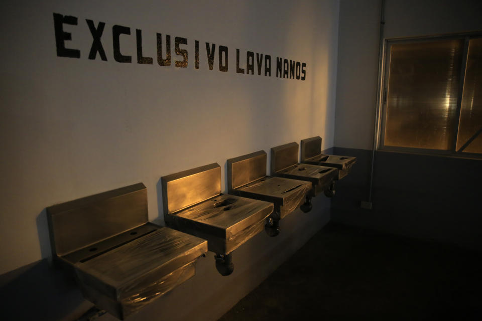 Sinks are covered with cling wrap, under the Spanish message: "Exclusively hand washing," at the dining hall of the now closed Morelos detention center during a media tour of the former Islas Marias penal colony located off Mexico's Pacific coast, late Friday, March 15, 2019. When it closed in February, the penal colony housed just 659 prisoners. (AP Photo/Rebecca Blackwell)