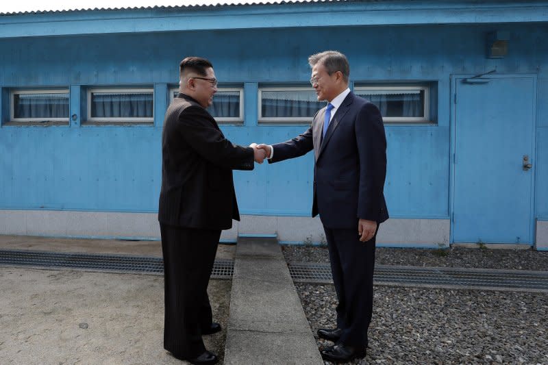 South Korean President Moon Jae-in (R) and North Korean leader Kim Jong Un shake hands in front of the Military Demarcation Line at the Joint Security Area on the Demilitarized Zone in the border village of Panmunjom in Paju, South Korea, on April 27, 2018. File Photo by Inter-Korean Summit Press Corps