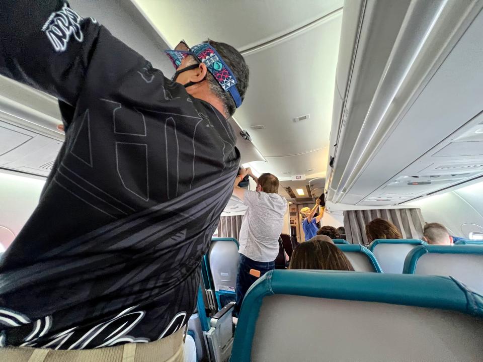 Passengers putting luggage into storage on a flight