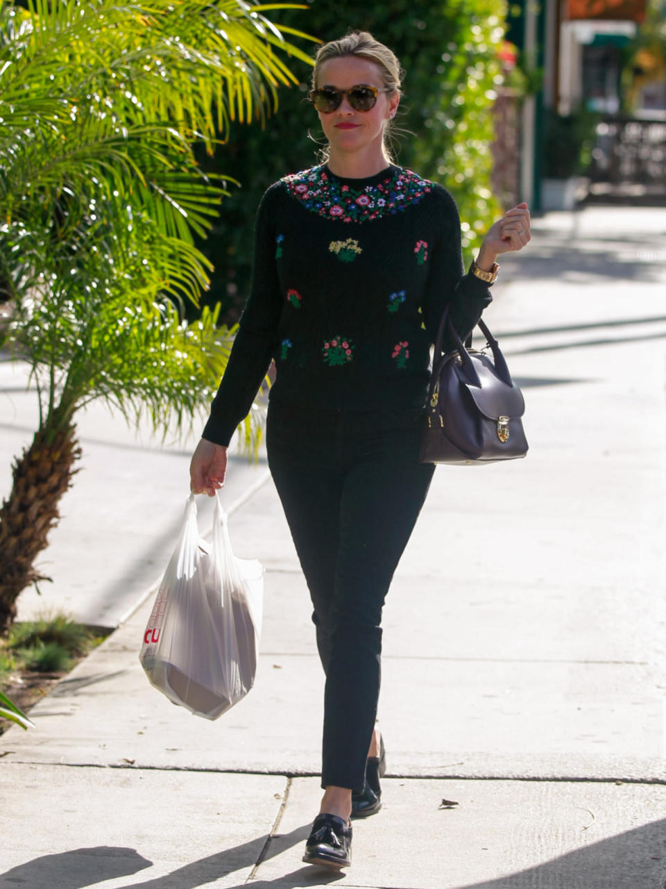 Reese Witherspoon wears a black sweater with floral embroidery, ankle jeans, and tassel loafers on Jan. 7, 2016 in Los Angeles, California.