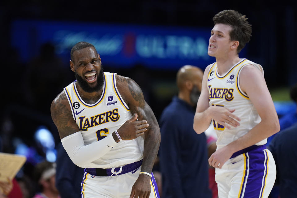 Los Angeles Lakers' LeBron James (6) celebrates with Austin Reaves (15) after making a basket assisted by Reaves during the first half of an NBA basketball game against the Washington Wizards, Sunday, Dec. 18, 2022, in Los Angeles. (AP Photo/Jae C. Hong)