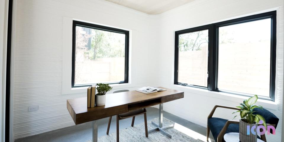 an office with a desk and large windows