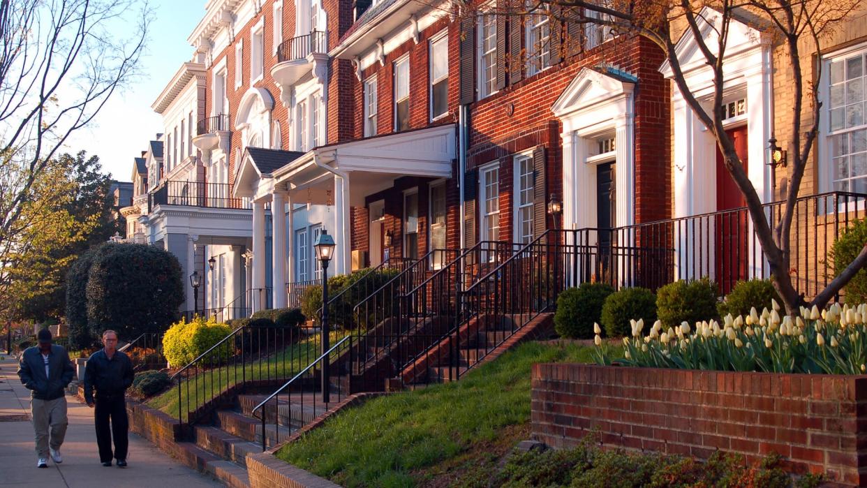 Richmond, VA, USA April 4, 2006 Two adult men walk past the historic homes on Monument Avenue in Richmond, Virginia.