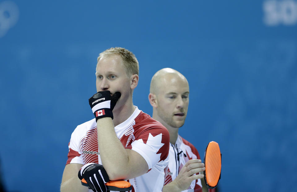 Canada's skip, Brad Jacobs, left, and Ryan Fry, right, wait for their turn to curl during the men's curling competition against Germany at the 2014 Winter Olympics, Monday, Feb. 10, 2014, in Sochi, Russia. (AP Photo/Wong Maye-E)