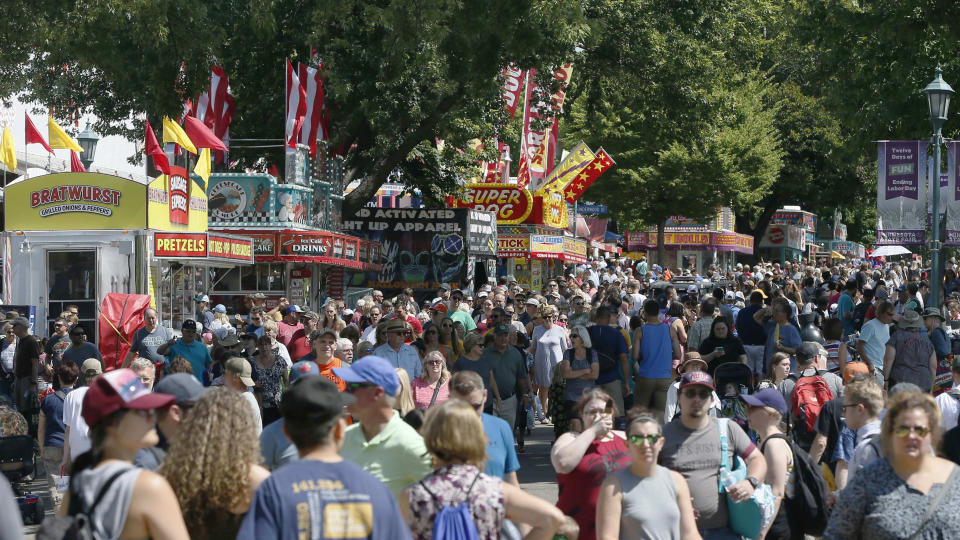 FILE - In this Aug. 22, 2019 file photo, thousands packed the Minnesota State Fair fairgrounds as the 12-day Fair got underway in Falcon Heights, Minn. Minnesota State Fair officials strongly urged fairgoers Wednesday, Aug. 18, 2021, to mask up both inside and outside but stopped short of imposing any mandates to fight the highly contagious delta variant of the coronavirus at the Great Minnesota-Get Together. The state fair opens Aug. 26, and runs through Labor Day. (AP Photo/Jim Mone,File)