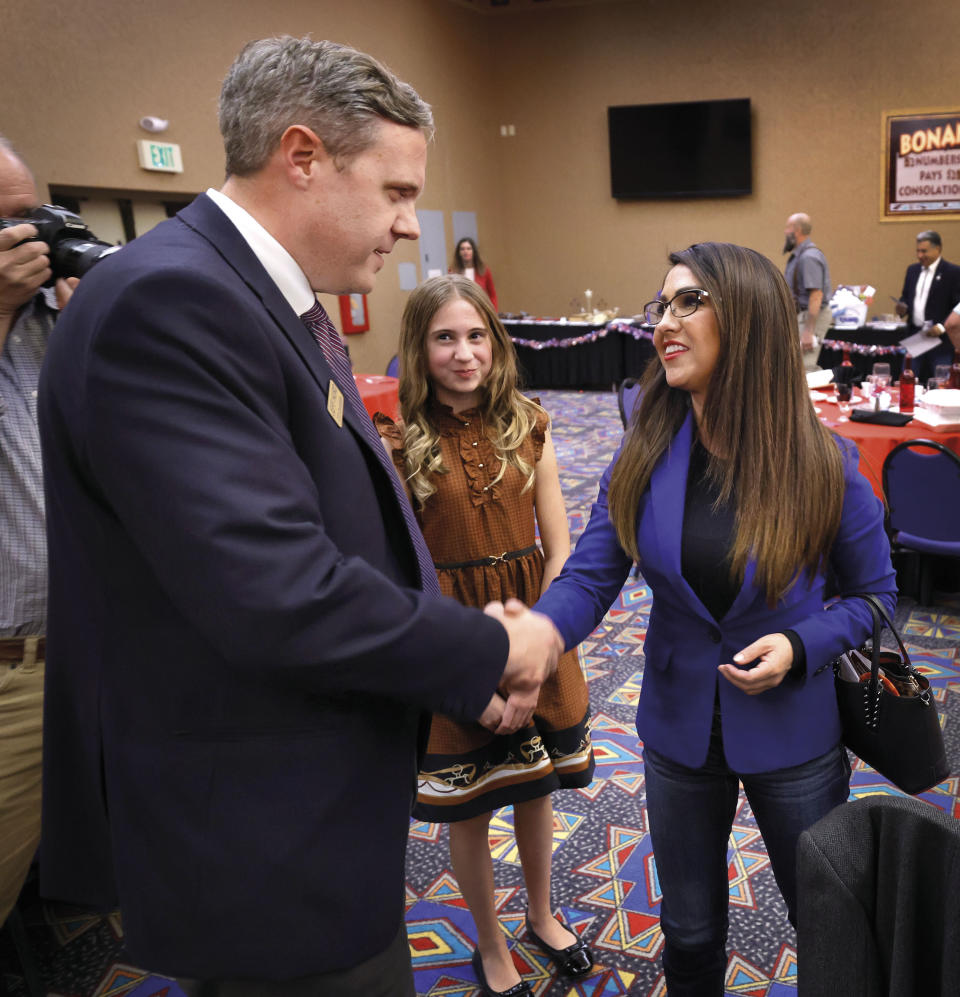 Rep. Lauren Boebert, R-Colo., shakes hands with attorney Jeff Hurd of Grand Junction, Colo., who is running against Boebert in Colorado's 3rd Congressional District, as his 12-year-old daughter Gabriella Hurd, stands nearby, Saturday, Oct. 28, 2023, in Towaoc, Colo. Boebert spoke at the Montezuma County Lincoln Day Dinner at the Ute Mountain Casino Hotel. (AP Photo/Jerry McBride)