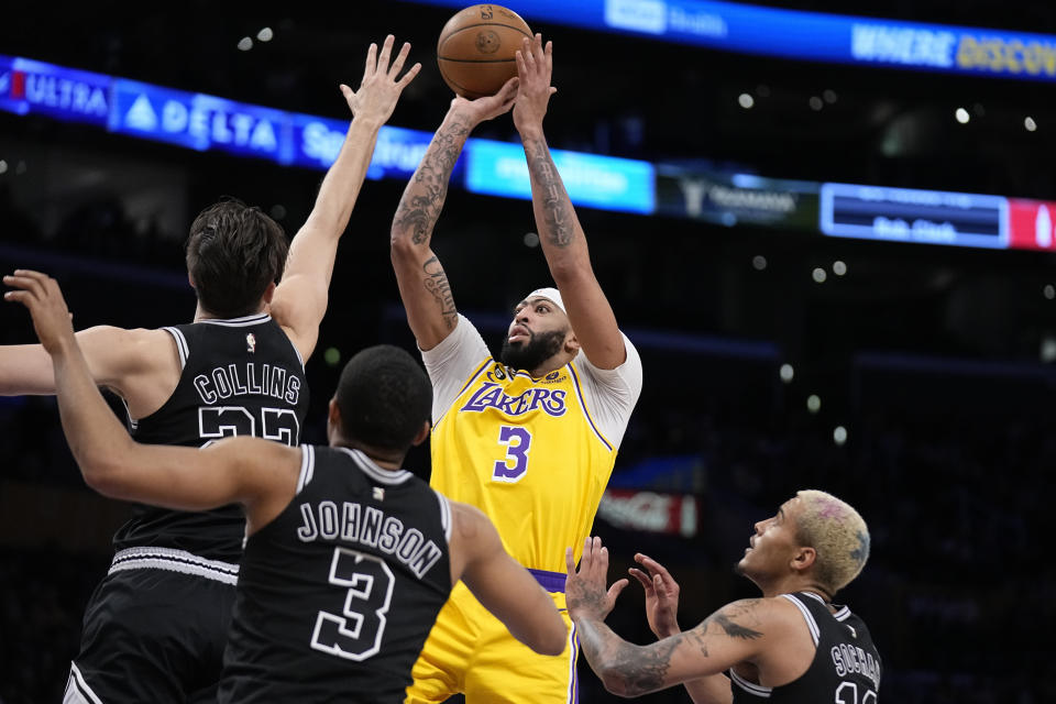 Los Angeles Lakers forward Anthony Davis, second from right, shoots as San Antonio Spurs forward Zach Collins, left, forward Keldon Johnson, second from right, and forward Jeremy Sochan defend during the first half of an NBA basketball game Wednesday, Jan. 25, 2023, in Los Angeles. (AP Photo/Mark J. Terrill)