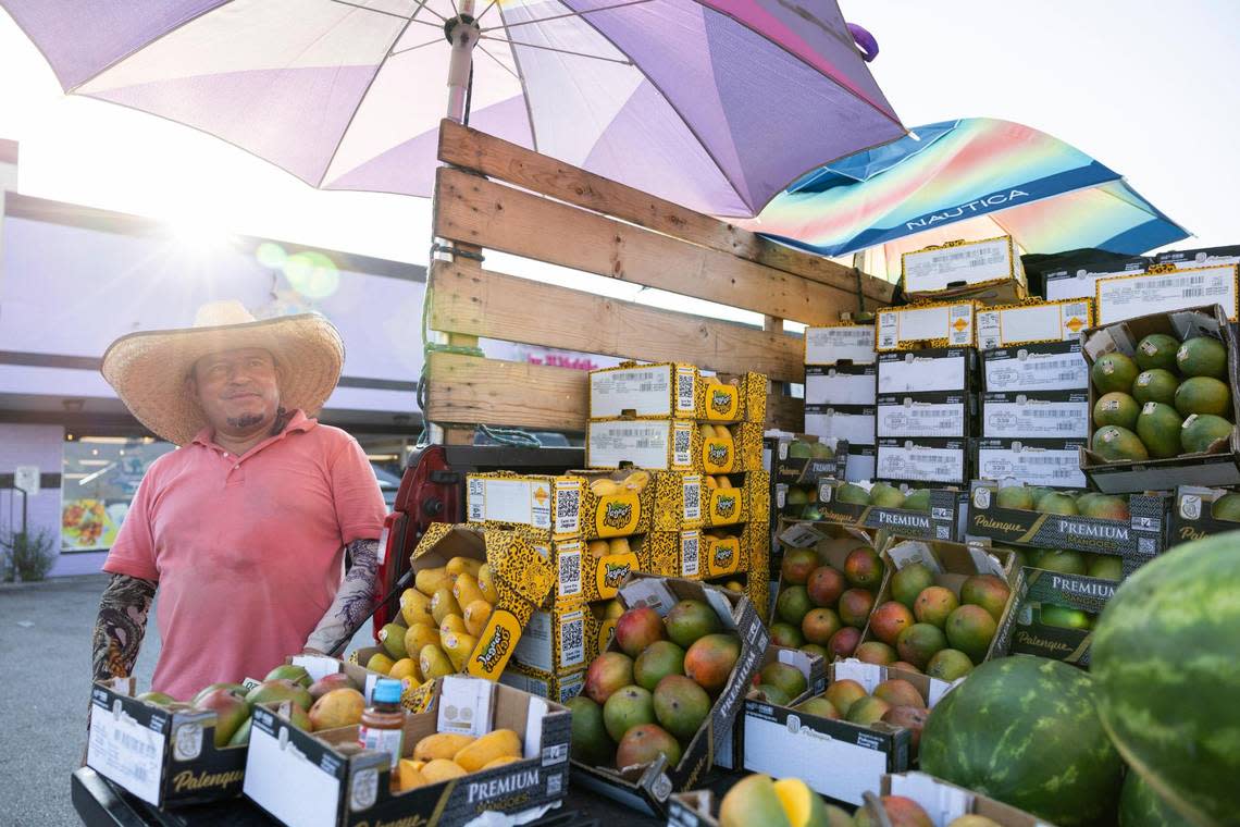Raymundo Rumond Reyes sells mangoes and watermelons out of the back of his truck in a parking lot off of Alexandria Drive near the Cardinal Valley neighborhood in Lexington, Ky., Friday, July 28, 2023.