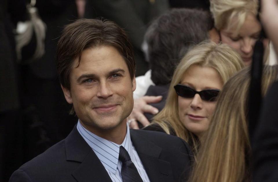 Actor Rob Lowe sits with a friend prior to the swearing-in of Gov. Arnold Schwarzenegger at the west steps of the state Capitol on Nov. 17, 2003.