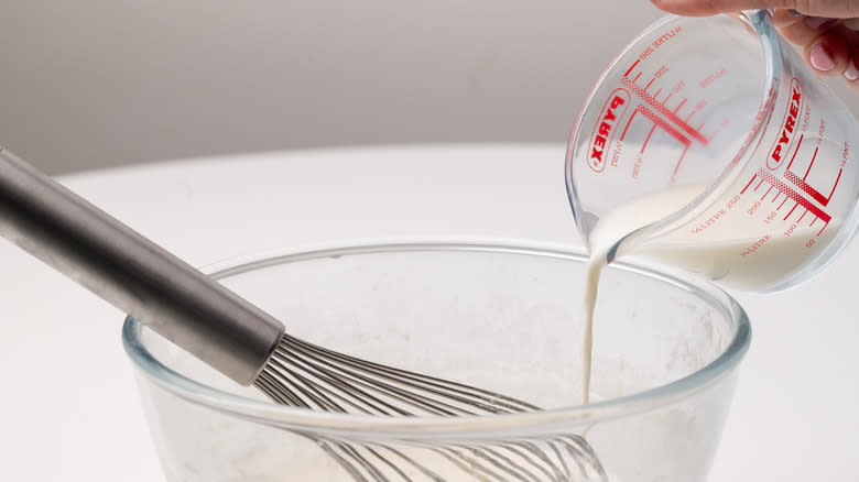 pouring milk into crepe batter