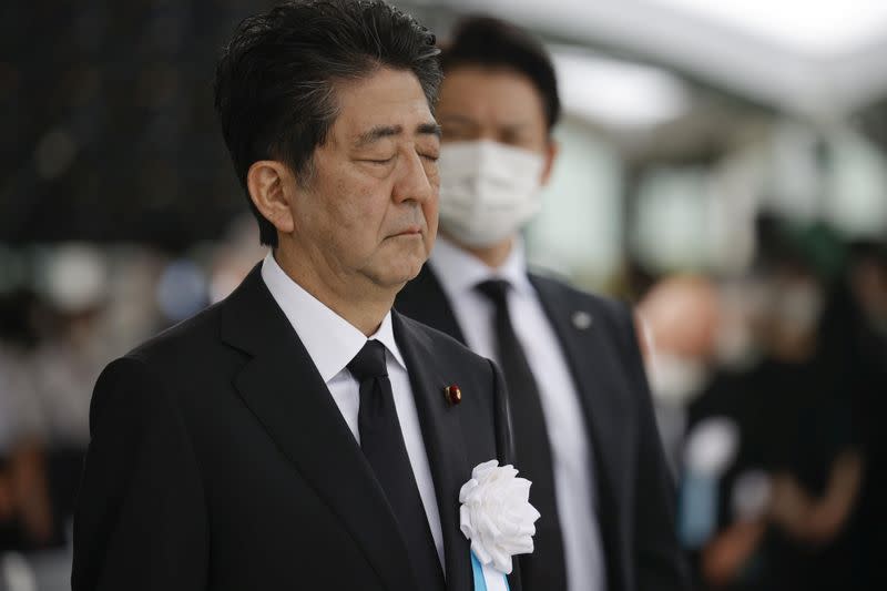 Japan's Prime Minister Shinzo Abe offers a silent prayer for the victims of the 1945 atomic bombing, at Peace Memorial Park in Hiroshima, Japan