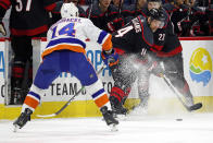 Carolina Hurricanes' Justin Williams, center, plays the puck in front of New York Islanders' Tom Kuhnhackl, left, of Germany, during the first period of an NHL hockey game in Raleigh, N.C., Sunday, Jan. 19, 2020. (AP Photo/Karl B DeBlaker)