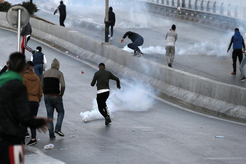 Protestors clash with police officers during a demonstration against the country's leadership, in Algiers, Friday, April 12, 2019. Heavy police deployment and repeated volleys of water cannon didn't deter masses of Algerians from packing the streets of the capital Friday, insisting that their revolution isn't over just because the president stepped down. (AP Photo/ Fateh Guidoum)