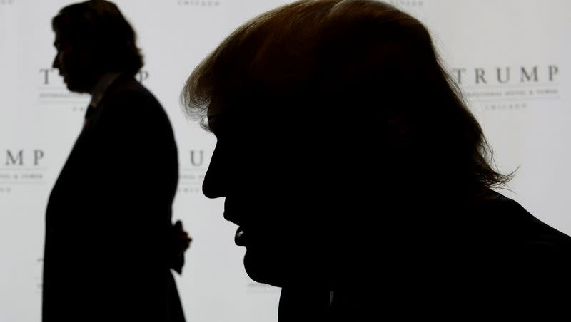 Donald Trump, right, talks with The Associated Press as his son, Donald Jr., gives an interview at Trump International Hotel and Tower in Chicago on Sept. 24, 2008. 